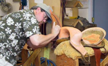 Randy George works on a bronc saddle